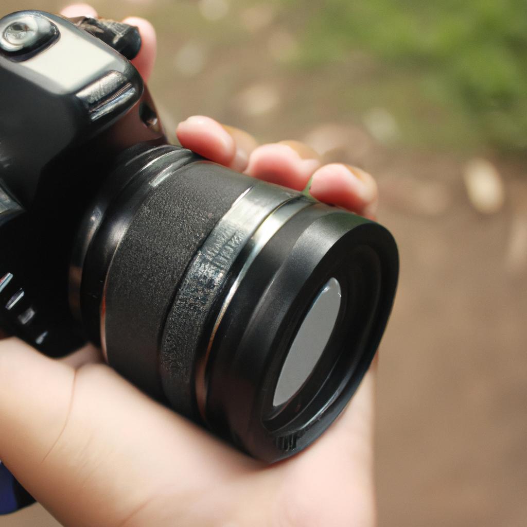 Person holding camera, adjusting lens